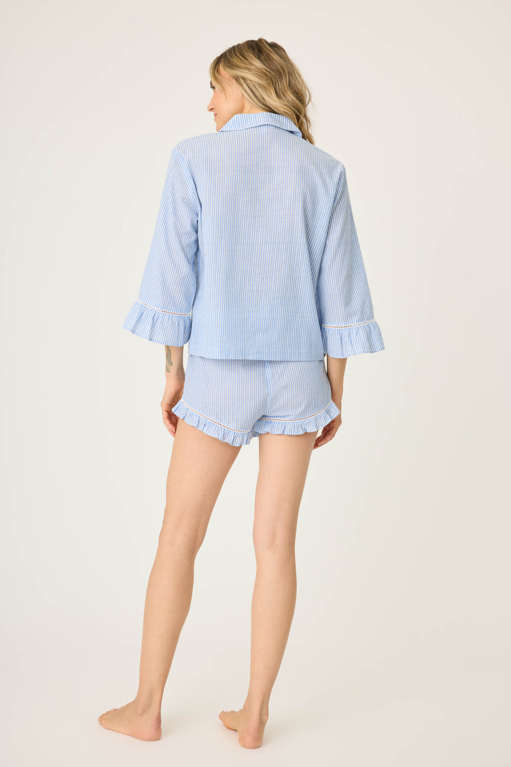 Women's blue & white striped sleep set. Cotton button front shirt with 3/4 ruffle sleeve. Short with ruffle hem & tassel tie waist.