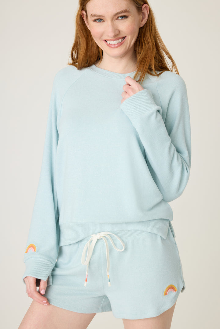 Women's blue melange lounge short with small rainbow embroidery on cuff.