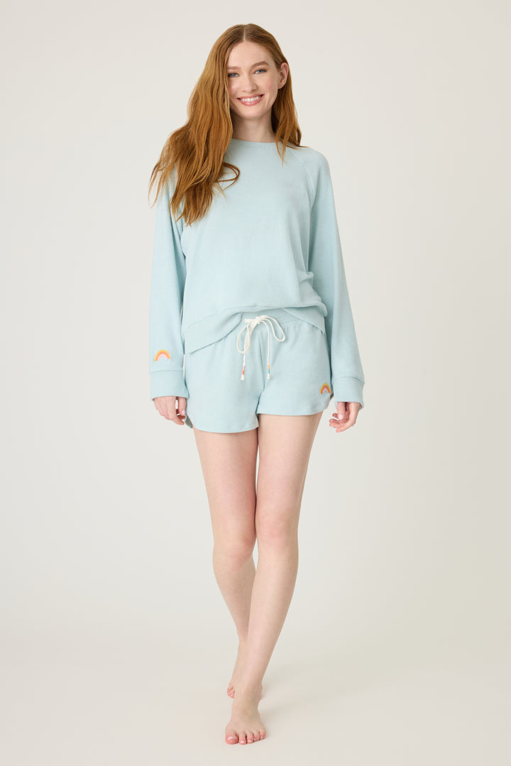 Women's blue melange lounge short with small rainbow embroidery on cuff.