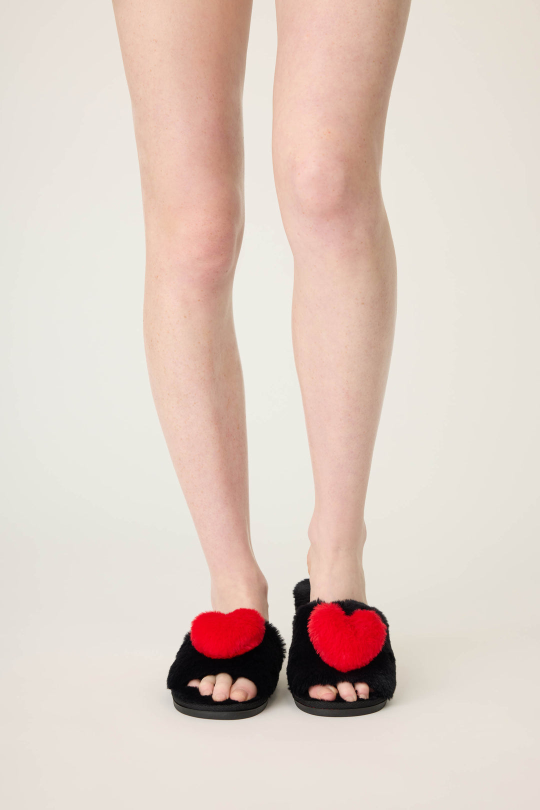 Women's black slippers with red heart.