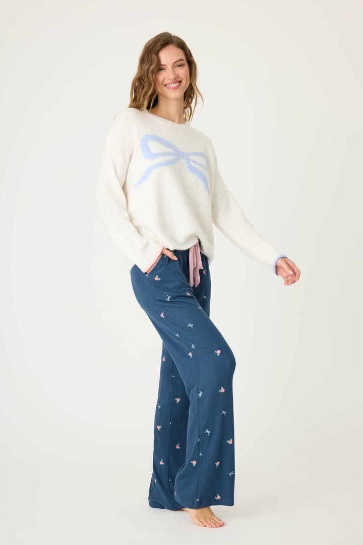 Women's ivory snuggle sweater with pink bow knitted graphic on front.