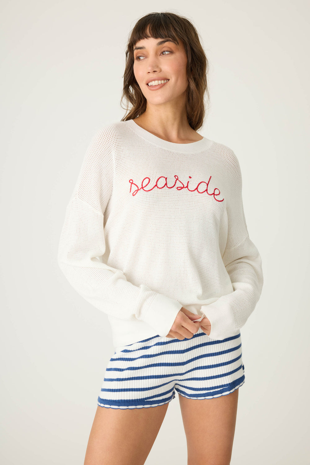 Ivory open-weave knit sweater with airy look & 'seaside' in red lettering embroidery.