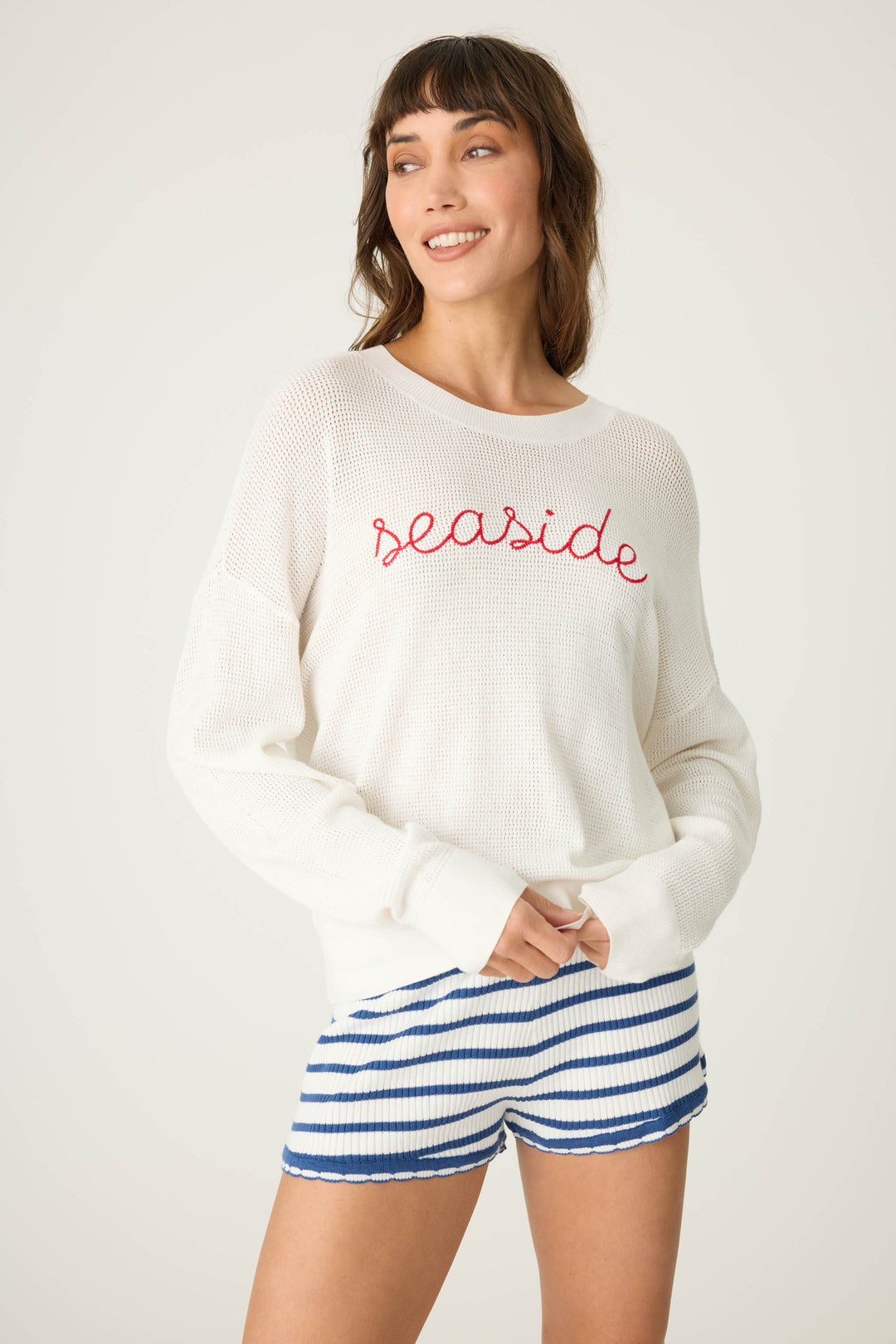 Ivory open-weave knit sweater with airy look & 'seaside' in red lettering embroidery.