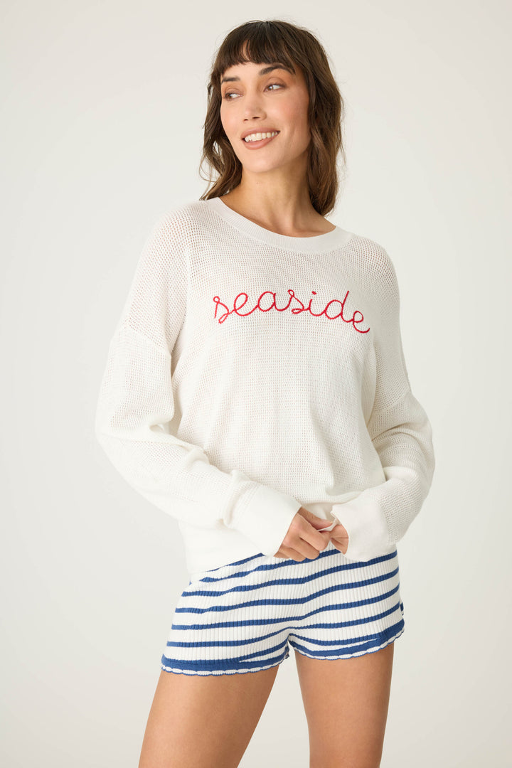 Ivory open-weave knit sweater with airy look & 'seaside' in red lettering embroidery.