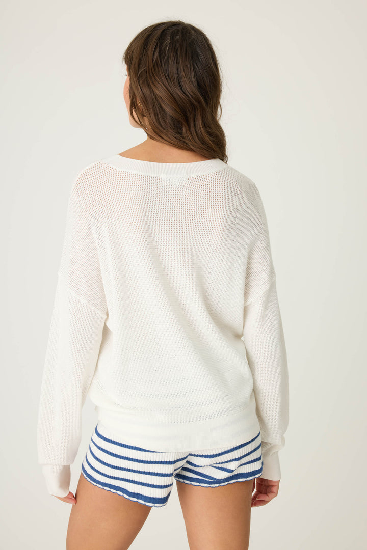 Ivory open-weave knit sweater with airy look & 'seaside' in red lettering embroidery.