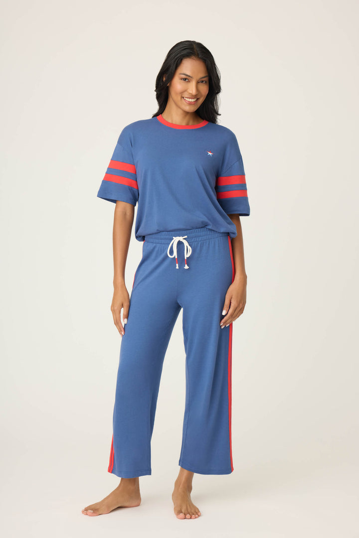Women's navy crop lounge pant. Red side stripes & drawcord detail. Elastic & tie waist.