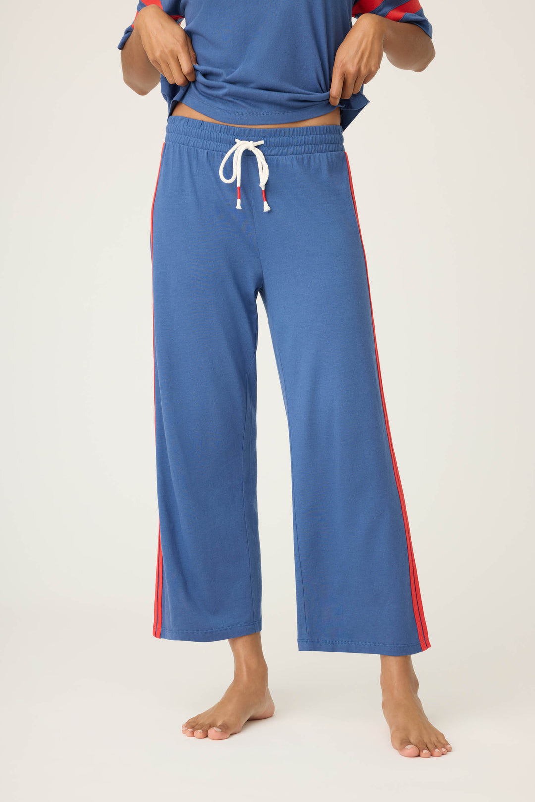 Women's navy crop lounge pant. Red side stripes & drawcord detail. Elastic & tie waist.