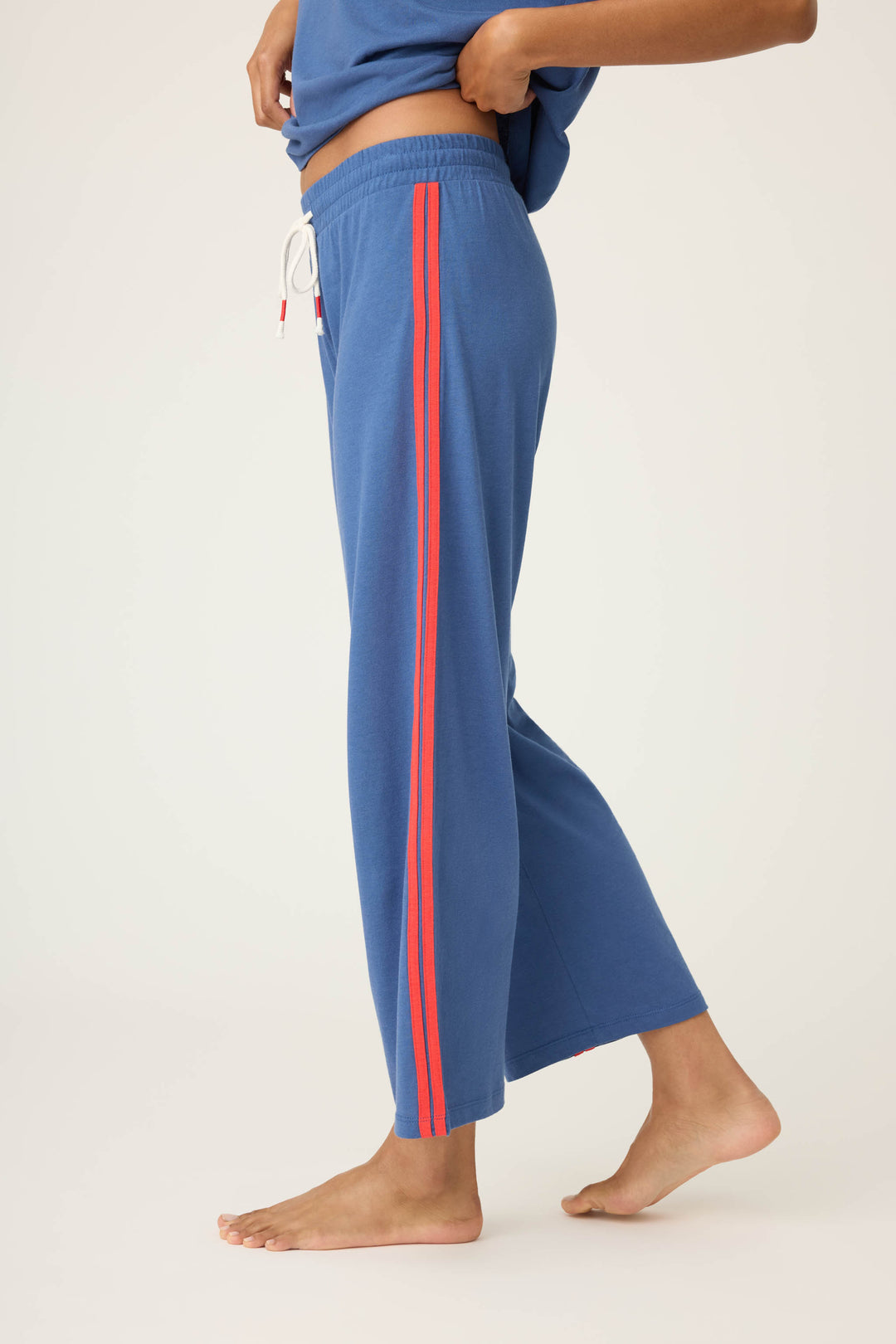 Women's navy crop lounge pant. Red side stripes & drawcord detail. Elastic & tie waist.