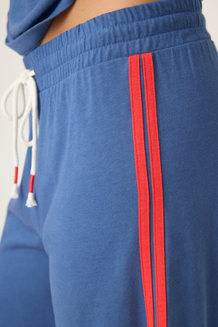 Women's navy crop lounge pant. Red side stripes & drawcord detail. Elastic & tie waist.