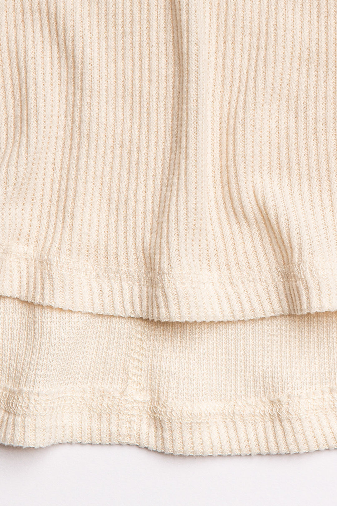 Ivory V-neck top with relaxed fit in 2x2 peachy rib. Banded sleeve cuff & neck rib. (7122611667044)