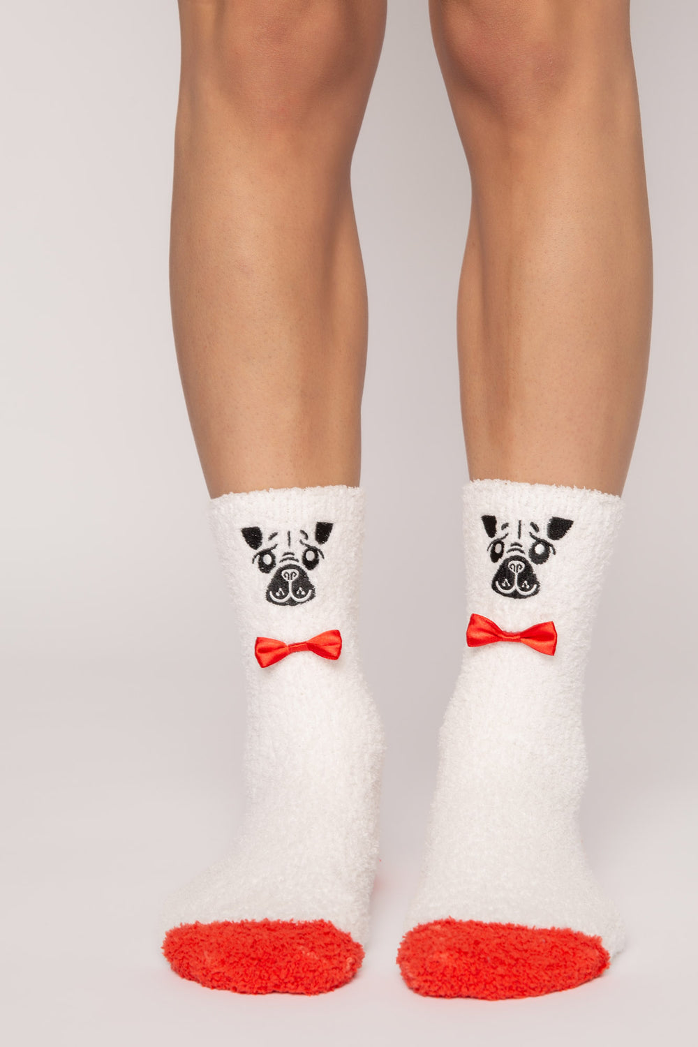 Ivory cozy plush socks with knitted dog face & bowtie. Clear-printed grippers on soles. (7231871942756)