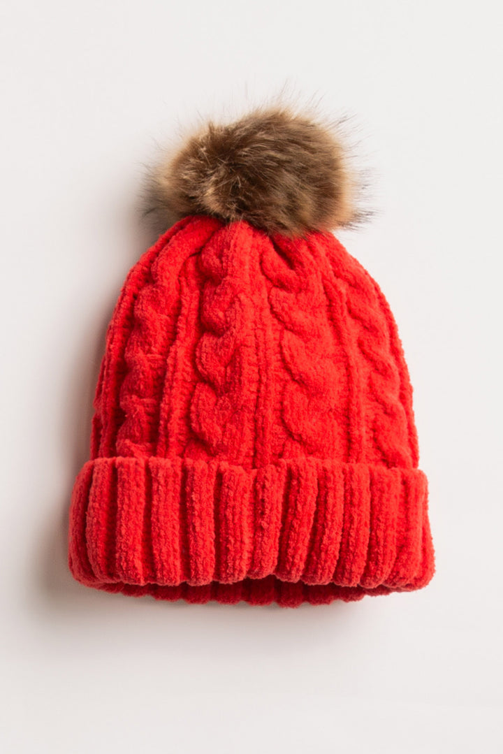 Beanie hat in red chenille knit cable pattern. Tan faux fur pom-pom on top. (7257677955172)