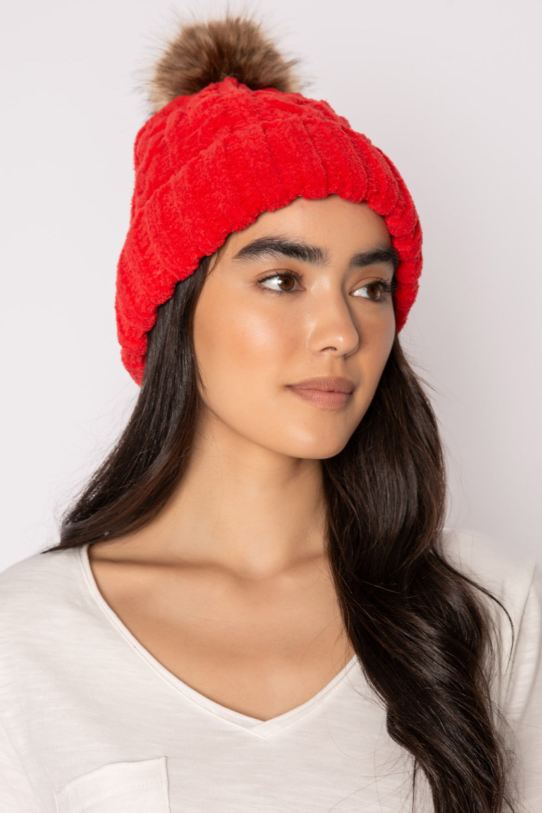 Beanie hat in red chenille knit cable pattern. Tan faux fur pom-pom on top. (7257677955172)