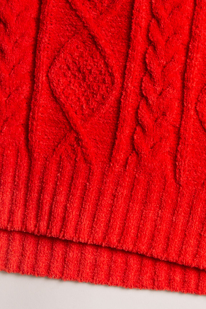 Beanie hat in red chenille knit cable pattern. Tan faux fur pom-pom on top. (7257677955172)