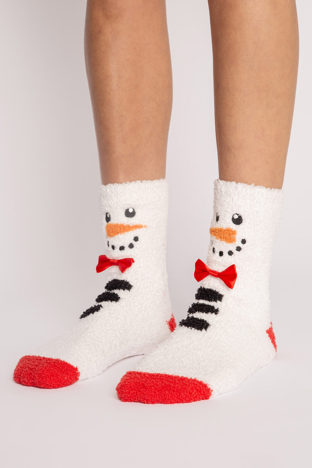 Ivory plush sock with knit snowman-face eyes, nose, bow-tie details. Gripper print on soles for non-skid. (7257678938212)