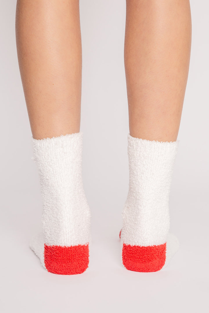Ivory plush sock with knit snowman-face eyes, nose, bow-tie details. Gripper print on soles for non-skid. (7257678938212)