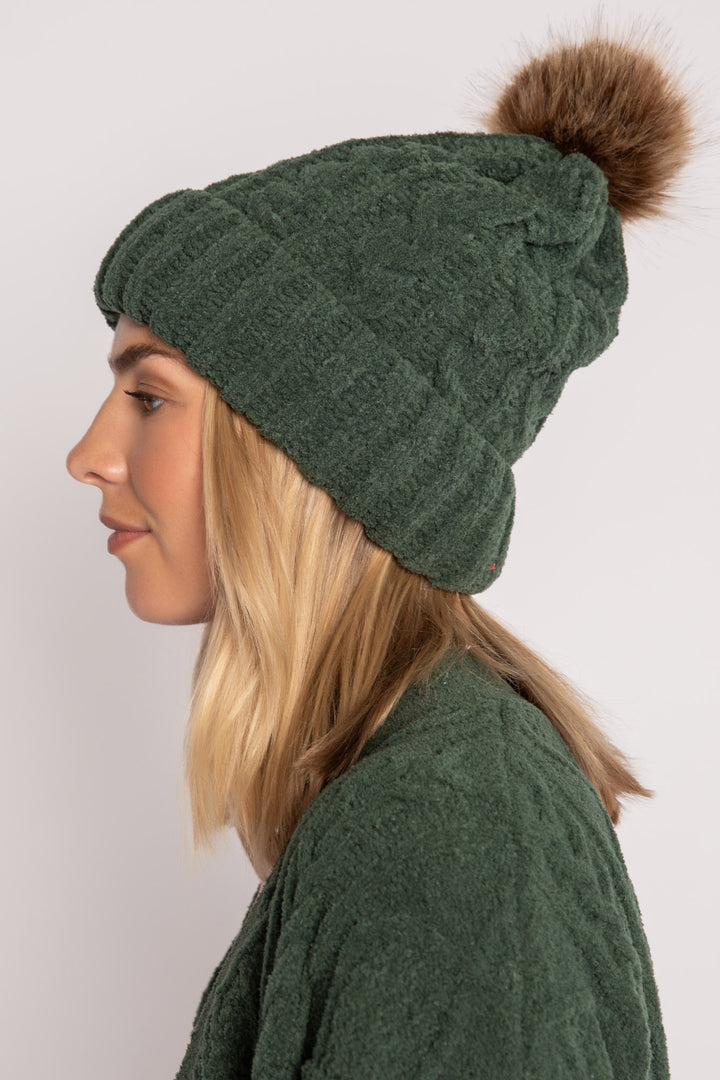 Beanie hat in dark green chenille knit with cable pattern. Tan pom-pom puff at top. (7257679265892)