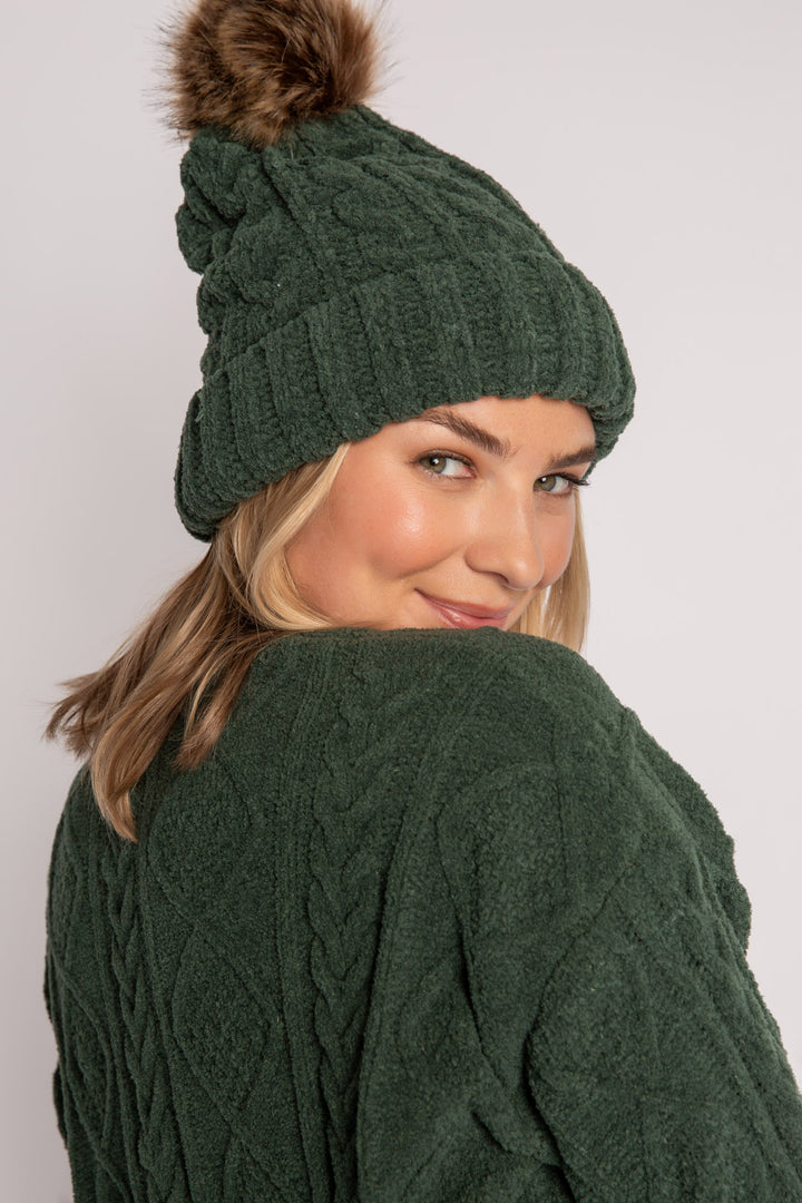 Beanie hat in dark green chenille knit with cable pattern. Tan pom-pom puff at top. (7257679265892)
