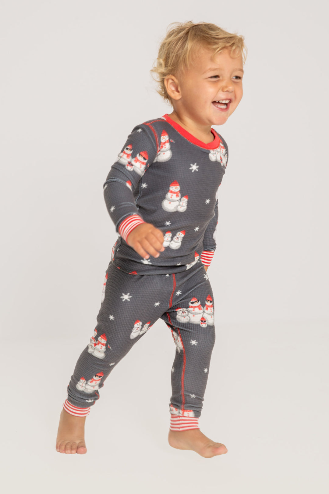 Kids' gender-neutral pj set in grey thermal velour with snowman print. Red & white striped cuffs. (7257679659108)