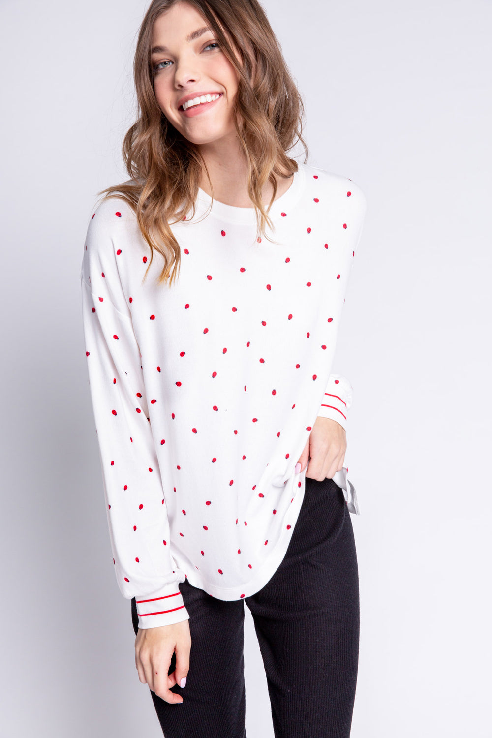 Soft ivory lounge top with lady bug print and striped red cuffs. Relaxed fit. (6639335997540)