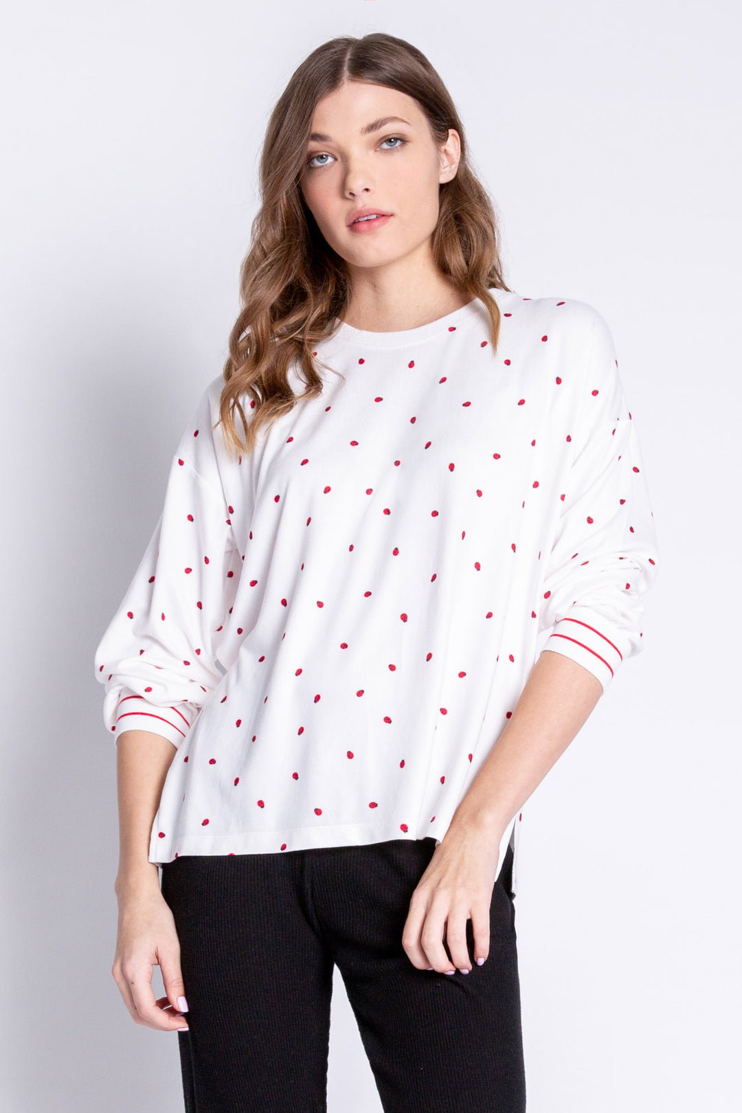 Soft ivory lounge top with lady bug print and striped red cuffs. Relaxed fit. (6639335997540)