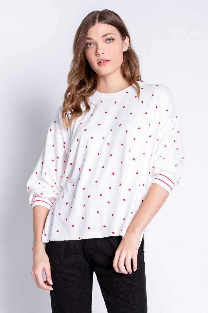 Soft ivory lounge top with lady bug print and striped red cuffs. Relaxed fit. (6639335997540)
