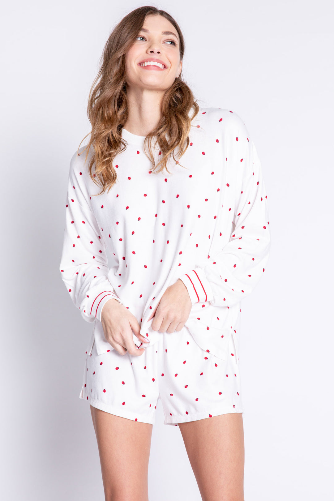 Soft ivory lounge top with lady bug print and striped red cuffs. Relaxed fit. (6639335997540)
