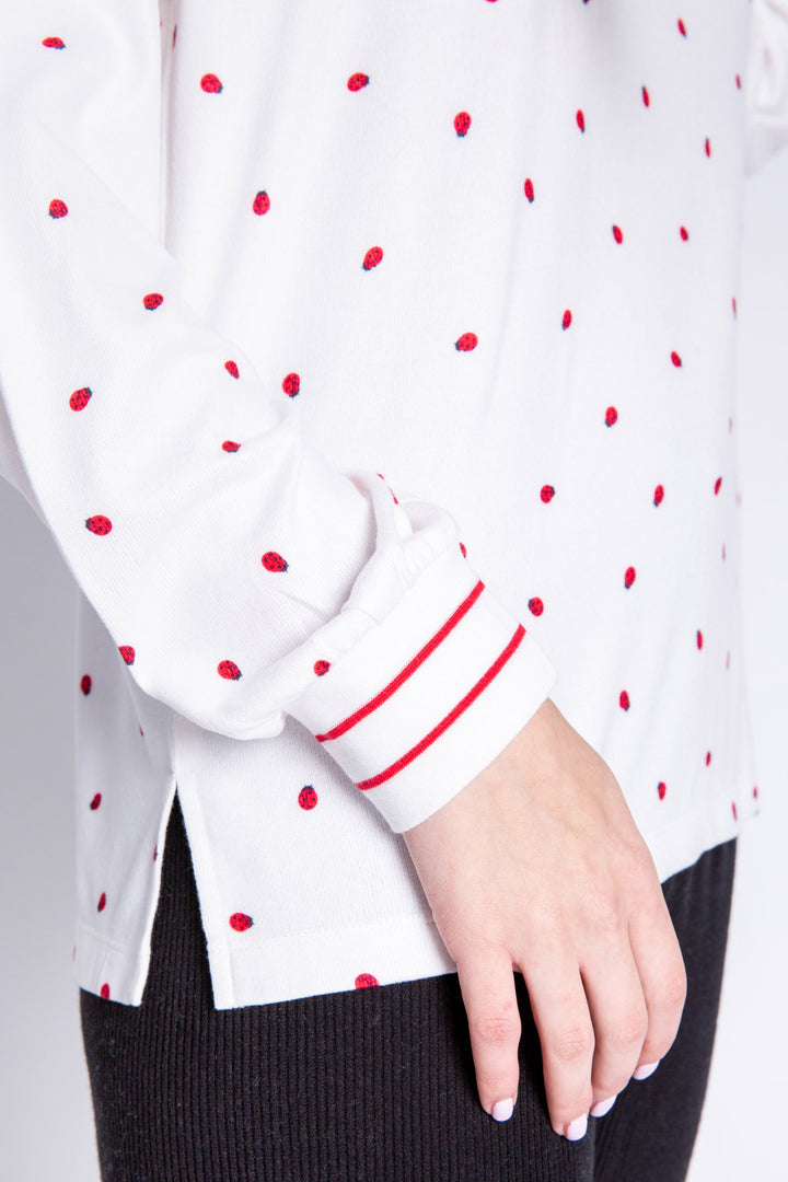 Soft ivory lounge top with lady bug print and striped red cuffs. Relaxed fit. (6639335997540)