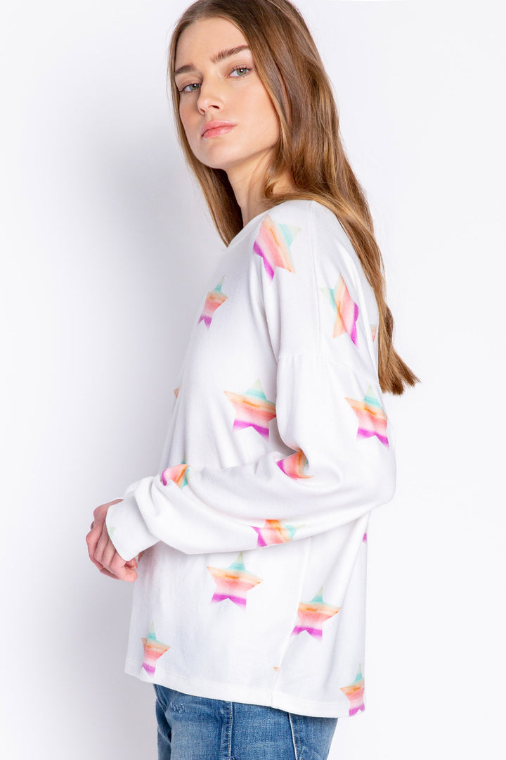 Soft ivory long sleeve top with multi-color gradient star print. Relaxed fit with open hem. (6839656611940)