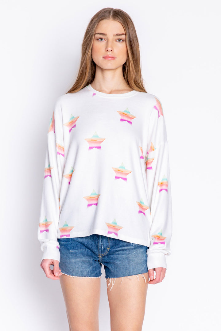 Soft ivory long sleeve top with multi-color gradient star print. Relaxed fit with open hem. (6839656611940)