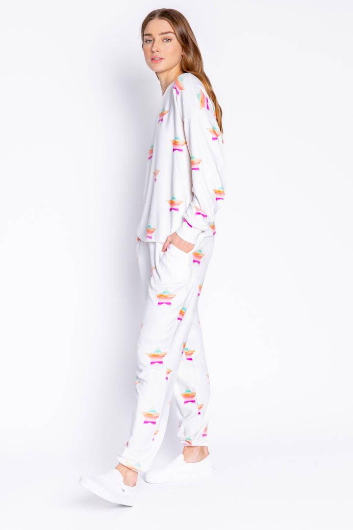 Soft ivory long sleeve top with multi-color gradient star print. Relaxed fit with open hem. (6839656611940)