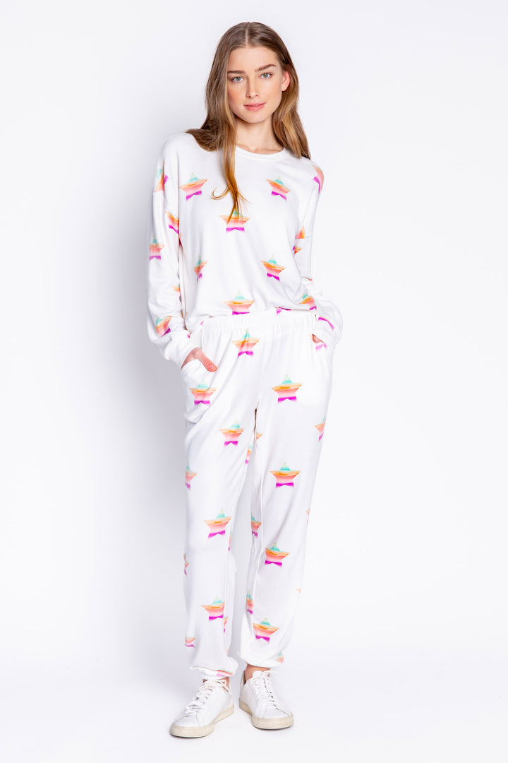Soft ivory long sleeve top with multi-color gradient star print. Relaxed fit with open hem. (6839656611940)